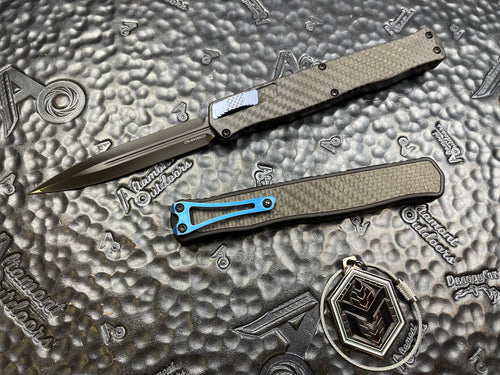 Heretic Knives Cleric II - Black ANO Chassis w/ Carbon Fiber inlay, Carbon Fiber Top Cover, DLC Double Edge Magnacut blade, Blue Ti Button and Blue Ti Clip  H020-6A-CF/BLU